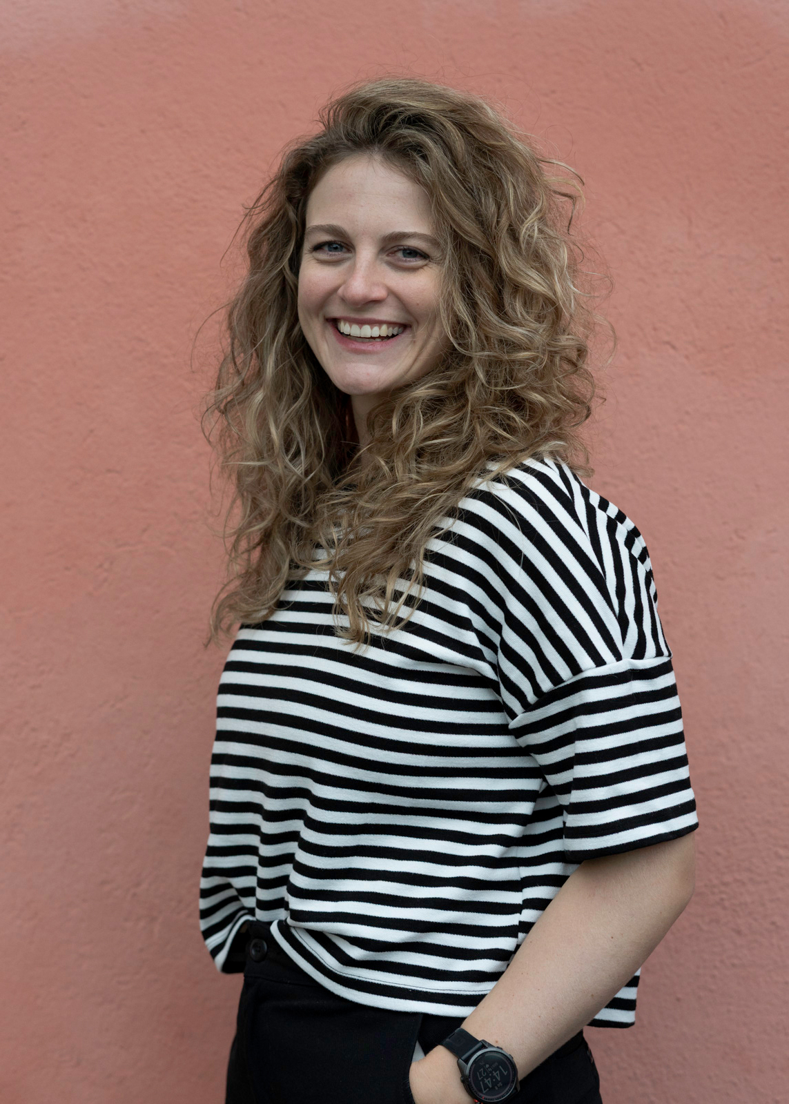 Frau im streifenshirt vor roter wand