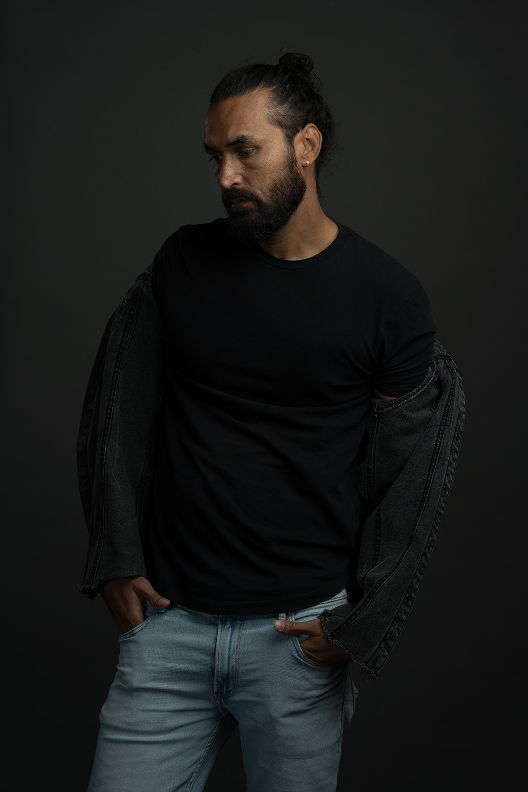 Mann mit jeansjacke ueber der schulter